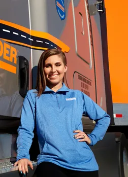 Student standing in from of large truck